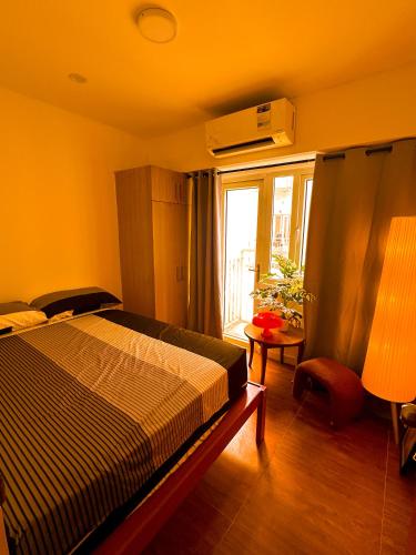 a bedroom with a bed and a window at Haus by Juju in Manila