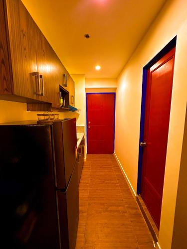 a hallway with a red door in a kitchen at Haus by Juju in Manila