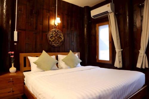ein Schlafzimmer mit einem großen weißen Bett und einem Fenster in der Unterkunft Doungploy BaanruenThai Homestay in Ban Hua Phrong