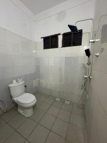 a white bathroom with a toilet and a shower at Spice Garden Lodge B&B in Zanzibar City