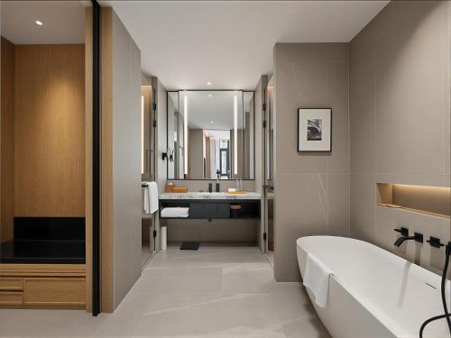 a bathroom with a tub and a sink at Four Points by Sheraton Qingtian in Qingtian