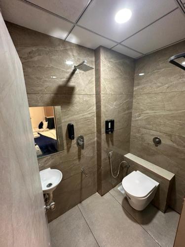 a bathroom with a toilet and a sink and a mirror at Hotel Crown in Dwarka