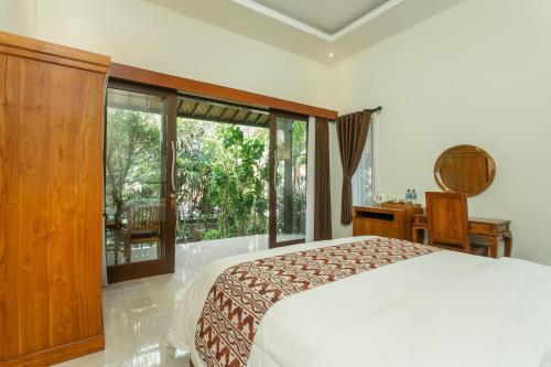 a bedroom with a bed and a large window at Yessi House in Ubud