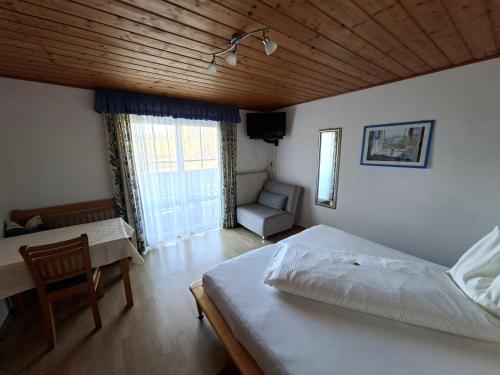 a bedroom with a bed and a desk and a chair at Pension Waldhof in Koppl