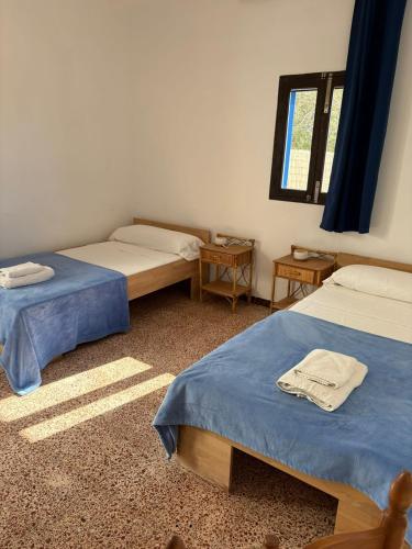 a room with two beds and a window at Casa Carpe Diem in Es Arenals