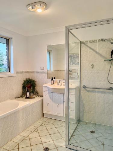 a bathroom with a shower and a tub and a sink at Beach Street Stay in Harrington