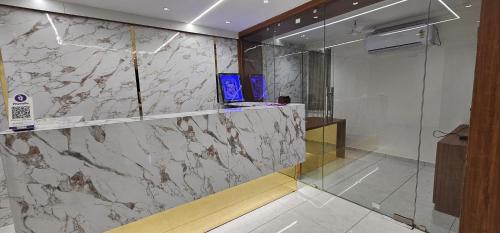 a lobby with a marble counter and a glass wall at Hotel Glory in Bavla