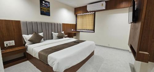 a bedroom with a large bed and a window at Hotel Glory in Bavla