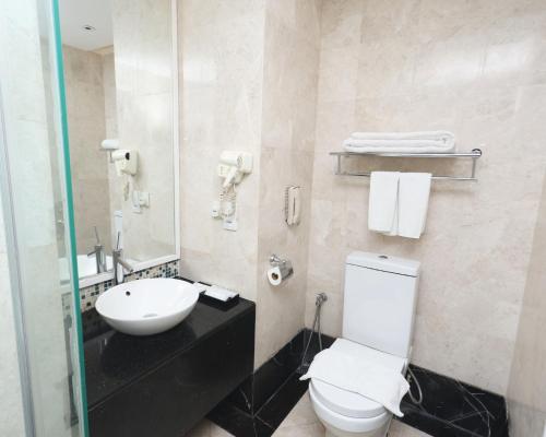 a bathroom with a white toilet and a sink at Perdana Kota Bharu in Kota Bharu