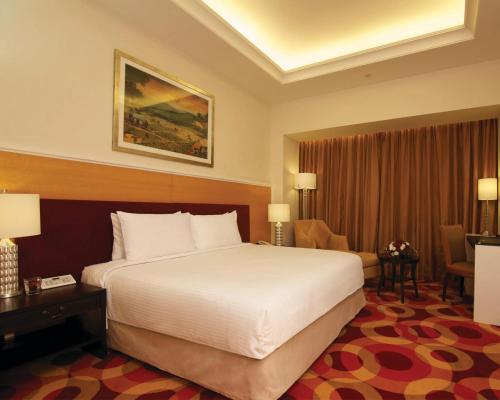 a hotel room with a large bed and a desk at Perdana Kota Bharu in Kota Bharu