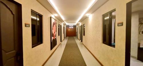 a hallway of a building with paintings on the walls at Dancenter Airport Hotel - Grey Hotel in Pampang