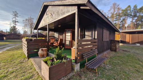 a small cabin with a bench in front of it at Chata Ještěrka in Doksy