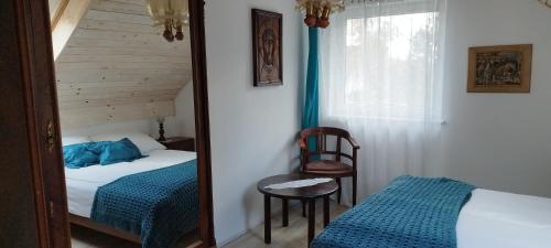 a mirror in a bedroom with a bed and a chair at Biały Domek in Radęcin