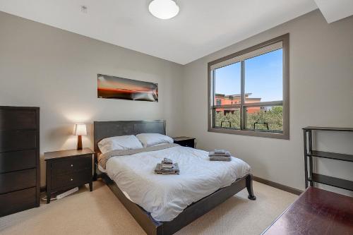 a bedroom with a bed and a window at Upper Floor w Courtyard View 550 in Kelowna