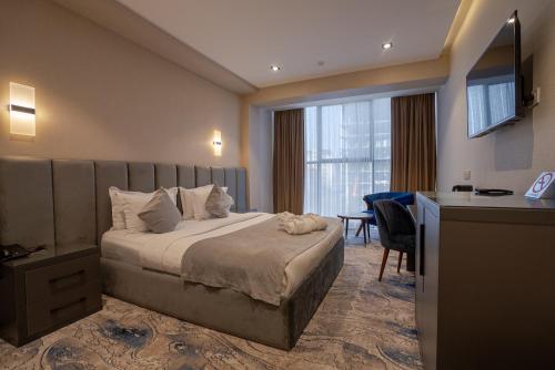 a hotel room with a bed and a desk at UNIQUE Airport Hotel in Tashkent