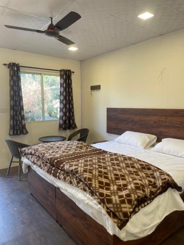 a bedroom with a large bed and a window at The Cottage Depot in Bīr