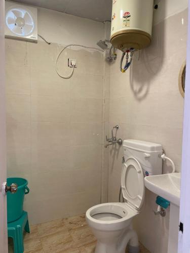 a bathroom with a toilet and a sink at The Cottage Depot in Bīr