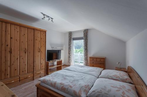a bedroom with a large bed and a window at Ferienwohnung Regentalblick in Miltach