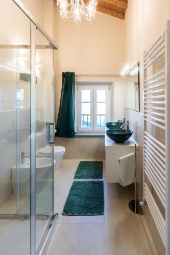 a bathroom with a glass shower and a sink at Lo scrigno di Camilla in Capannori