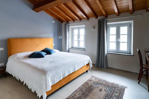 a bedroom with a large bed with blue pillows on it at Lo scrigno di Camilla in Capannori