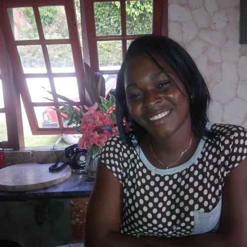 a woman in a polka dot shirt sitting at a table at Boutique B&B at Stone Village in Bluefields