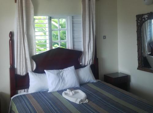 a bedroom with a bed with two towels on it at Boutique B&B at Stone Village in Bluefields