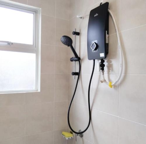 a shower with a blow dryer in a bathroom at Happpy Impiana Guest House in Bentong
