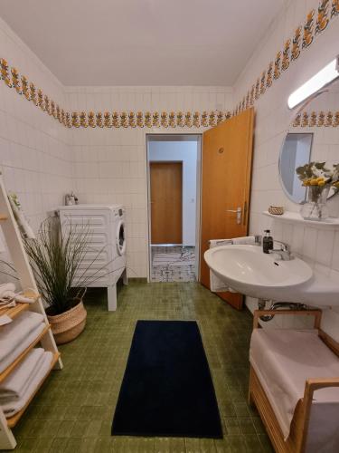 a bathroom with a sink and a bath tub and a sinkessment at Gemütliche Ferienwohnung mit Blick ins Grüne in Wadern