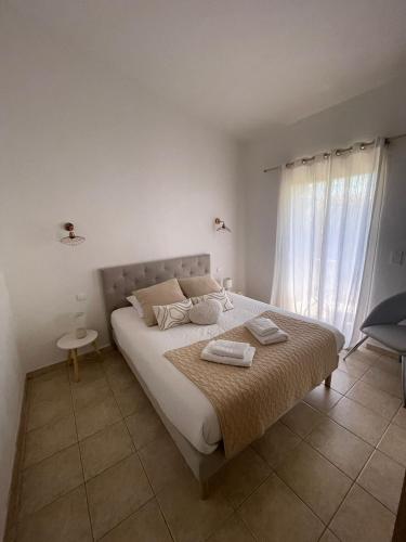 a bedroom with a bed with two towels on it at Mini villa proche plage Santa Giulia in Porto-Vecchio