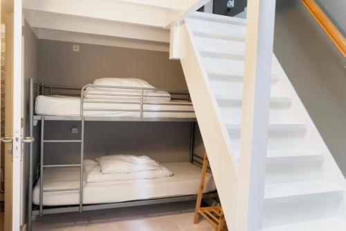 a bunk bed room with two bunk beds and a staircase at OP ZESTIEN in Hippolytushoef