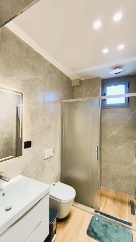 un bagno con doccia, WC e lavandino di Vila KAM a Vlorë