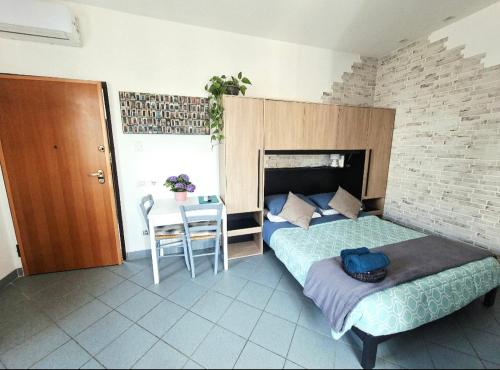 a bedroom with a bed and a table with a chair at Vinessa Home in Peschiera del Garda