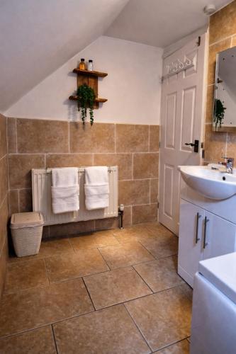 a bathroom with a sink and a toilet and towels at The Old Shop at Savile House - Sherwood Forest in Ollerton