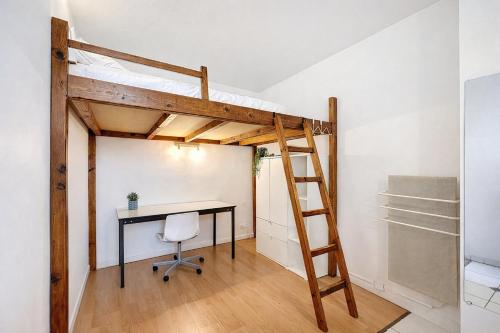 a loft bed in a room with a desk and a ladder at l'Azur Viennois in Vienne