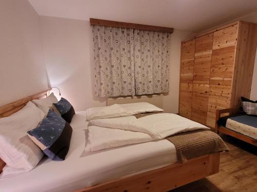 a bedroom with a bed with two pillows and a window at Ferienwohnung Schmiedhofer in Ellmau