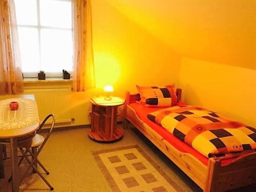 Un dormitorio con una cama y una mesa y una ventana. en Ferienwohnung Sievers, en Barlt
