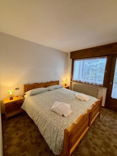 a bedroom with a large bed with two towels on it at Pragma Apartments - Cupido's Alpine Nest in Bellamonte