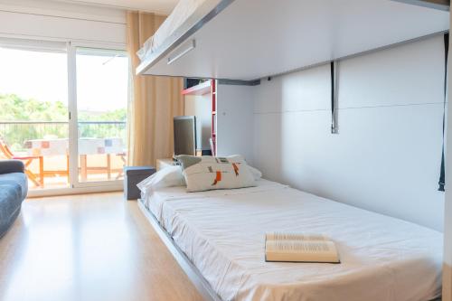 a bedroom with a bed with a book on it at Apartamento Serenity in Cunit