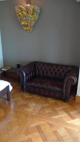 a brown leather couch sitting in a living room at La Bonne Auberge - Seine Panorama SAS in Vieux-Port