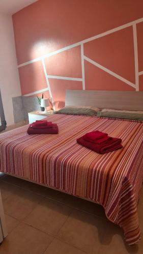 a large bed with two red towels on it at Casal Baratz in Santa Maria la Palma