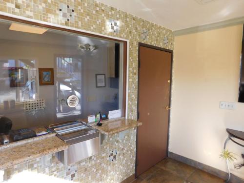 a kitchen with a sink and a tile wall at Continental Lodge in Oakland