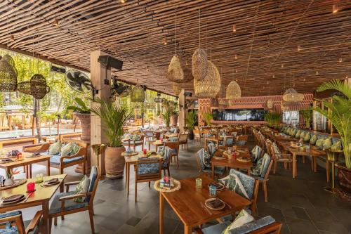 a restaurant with wooden ceilings and tables and chairs at Café del Mar Phuket - Suite & Penthouse in Kamala Beach