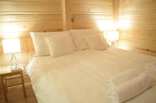 a bedroom with a white bed with two lamps at Chalet Pokljuka in Goreljek