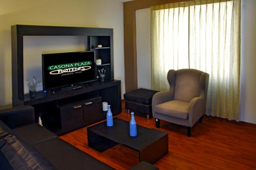 a living room with a couch and a tv and a chair at Casona Plaza Hotel Puno in Puno