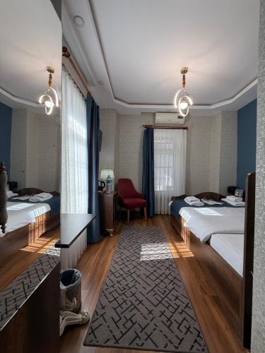 a hotel room with two beds and a red chair at La Vien Hotel Old City in Istanbul