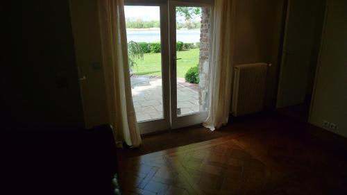 an open door with a view of a yard at La Bonne Auberge - Seine Panorama SAS in Vieux-Port