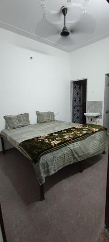 a large bed in a white room with a ceiling at बृजराज गेस्ट हाउस & rooms in Rīngas