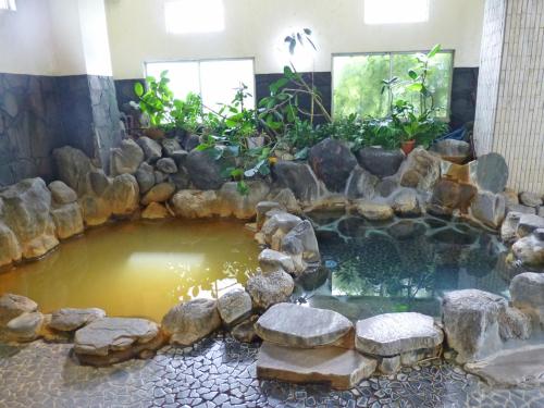 a pond in the middle of a room with rocks at Suisenkaku in Numazu