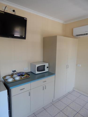 a kitchen with a microwave and a blue counter top at Jacksons Motor Inn in Adelaide