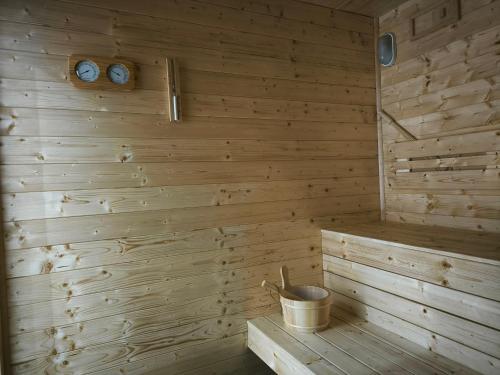 a sauna with a bucket and two clocks on the wall at Chalupa na Kopci in Liberec